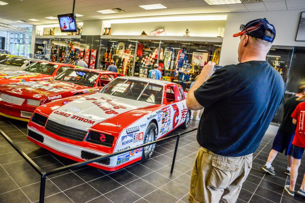 race fan taking photo of car on display